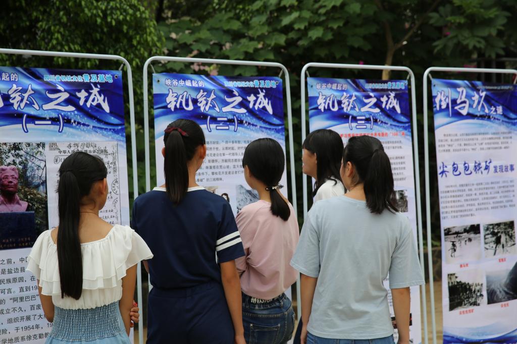 当地学生观看钒钛科文化普知识宣传展板